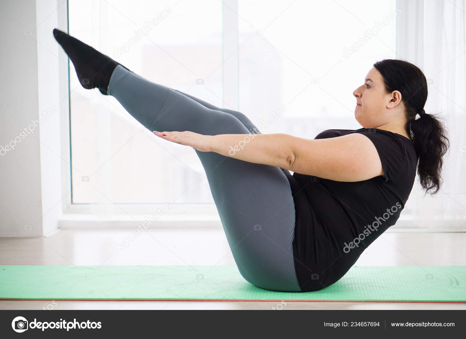 Overweight woman doing sit ups on mat at home Stock Photo Wadym 234657694