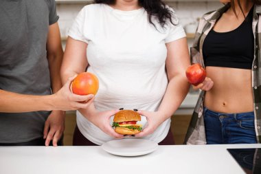 meyve ile burger ve uygun insanlarla obez kadın