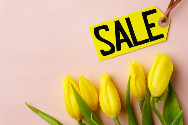 Venta vacaciones de primavera, etiqueta de precio y tulipanes amarillos — Foto de Stock