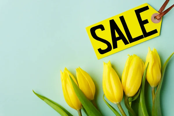 Venta vacaciones de primavera, etiqueta de precio y tulipanes amarillos — Foto de Stock