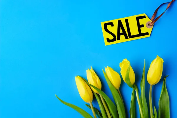 spring holidays sale, price tag and yellow tulips