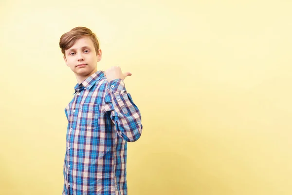 Självsäker pojke pekar på objektet bakom hans rygg — Stockfoto