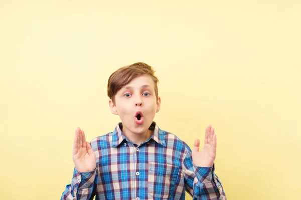 Stomverbaasd jongen met open mond op gele achtergrond — Stockfoto