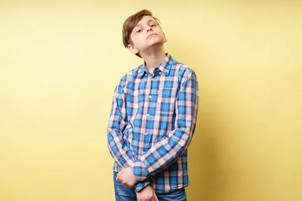 Arrogant högdragen säker pojke på gul bakgrund — Stockfoto