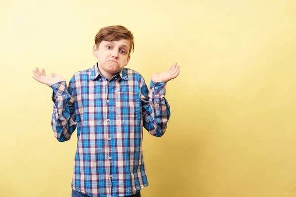 I dont know. clueless boy lifts hands in dismay — Stock Photo, Image