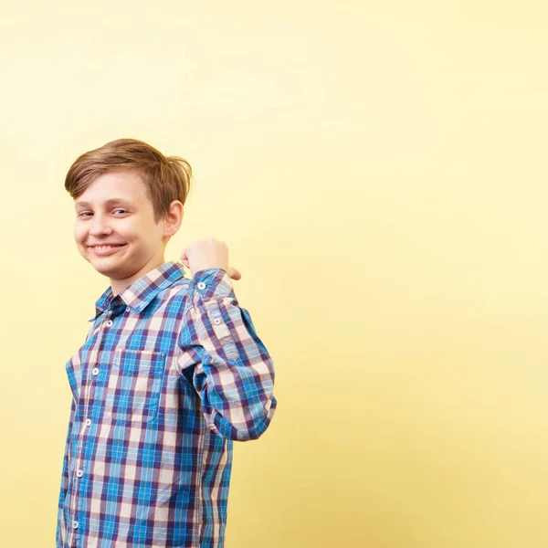 Leende pojke pekar på objektet bakom hans rygg — Stockfoto