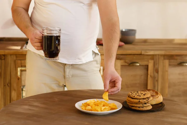 Hombre con sobrepeso con comida chatarra poco saludable y cerveza — Foto de Stock