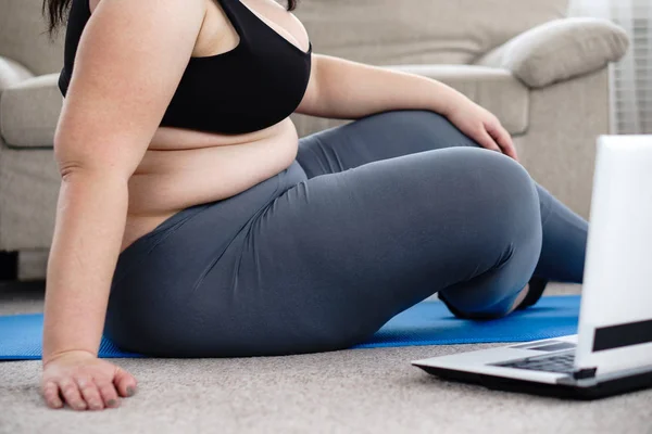 Надмірна вага жінка відпочиває після тренування йоги вдома — стокове фото