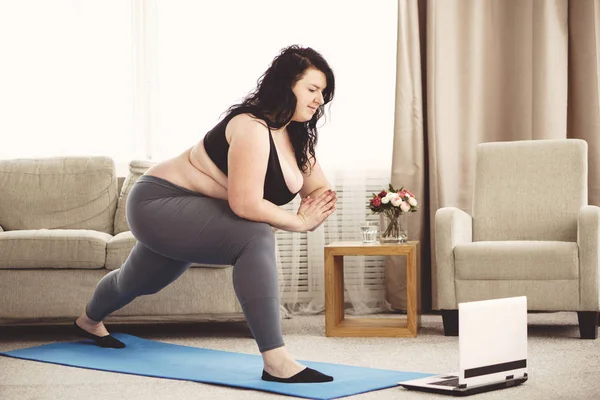 Wanita kelebihan berat badan melakukan latihan yoga di rumah — Stok Foto