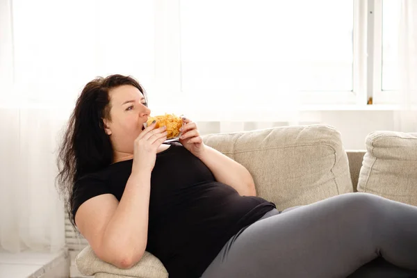 Жирна жінка переїдає нездорову їжу. спокійність — стокове фото