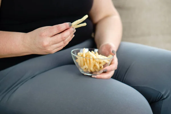 Mulher gorda a comer comida de plástico. sedentarismo — Fotografia de Stock