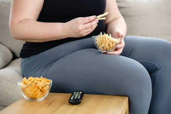 Donna in sovrappeso con telecomando tv e cibo spazzatura — Foto Stock