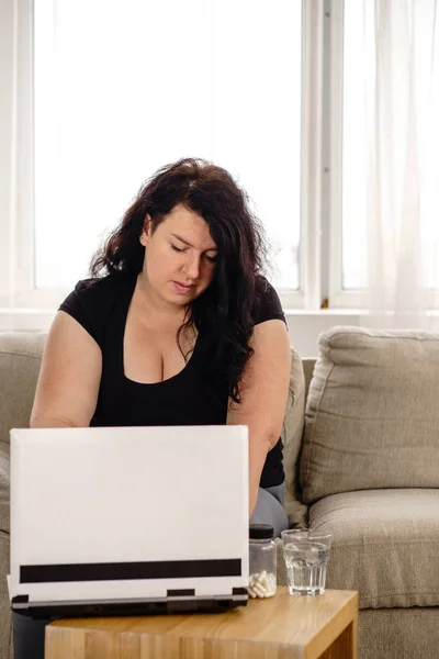 obese woman reading medical prescription for pills