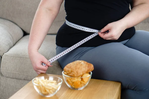 Соковита їжа. надмірна вага жінка вимірює обхват талії — стокове фото