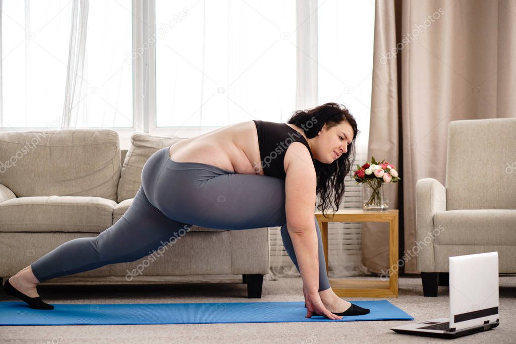 overweight woman stretching during home training