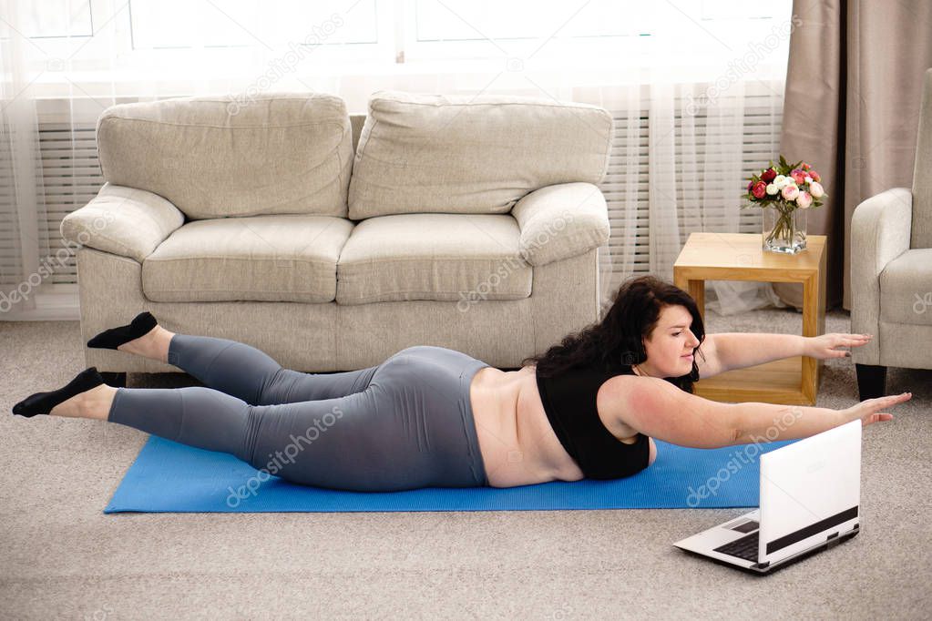 overweight woman performs hyperextension exercise