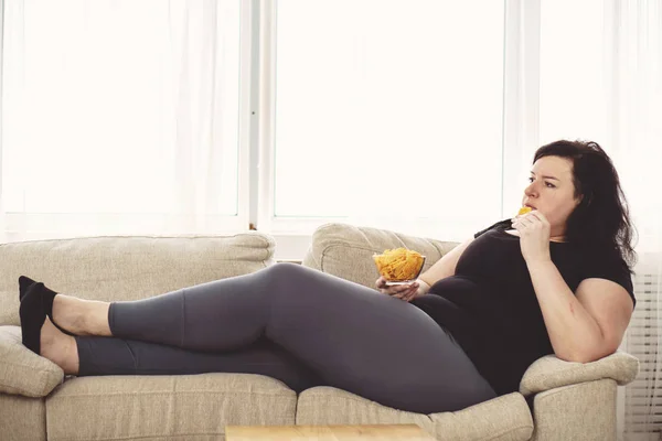 Gruba kobieta przejadanie fast foodów. do siedzącego trybu życia — Zdjęcie stockowe