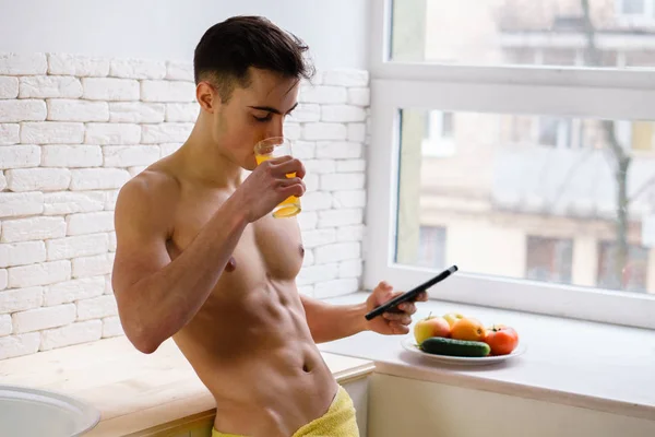 Σπορ άνθρωπος πίνει χυμό πορτοκάλι, χρησιμοποιώντας την εφαρμογή για κινητά — Φωτογραφία Αρχείου