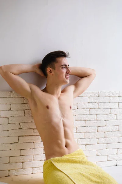 Молодая модель мускулистого мужчины позирует на домашней кухне — стоковое фото