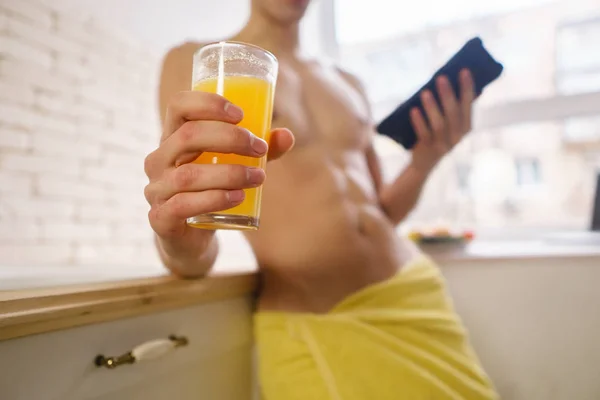 Sportif adam mobil app kullanarak portakal suyu içme — Stok fotoğraf