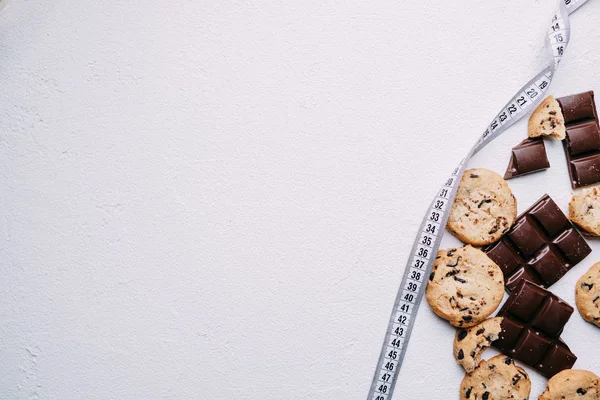 Dieta. fundo de biscoito de chocolate e fita métrica — Fotografia de Stock