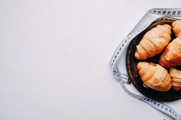 Croissants doces e fita métrica. dieta, aptidão — Fotografia de Stock