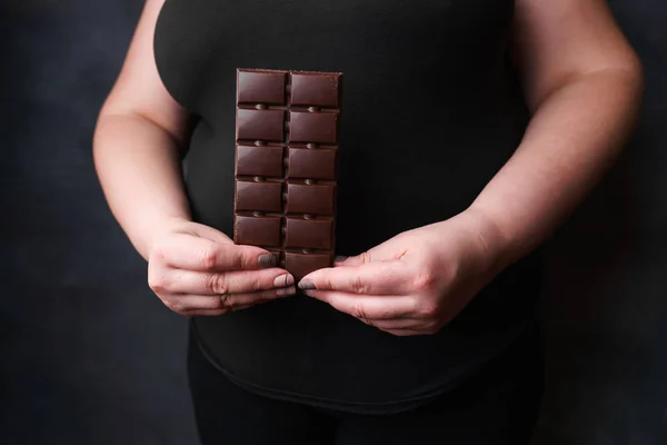 overweight woman with chocolate bar. weight loss