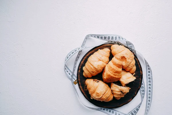 Croissants doces e fita métrica. dieta, aptidão — Fotografia de Stock