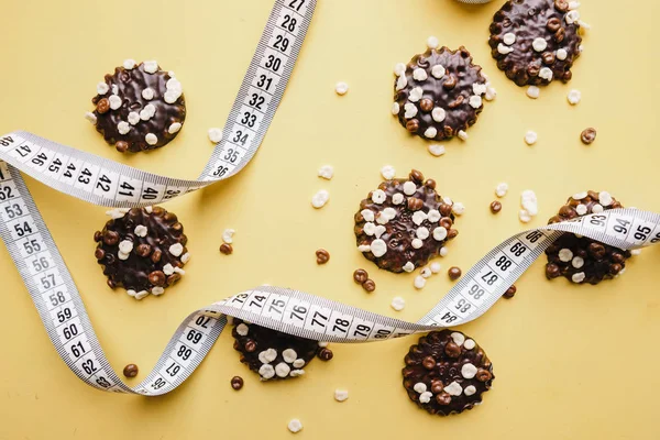 diet. chocolate cookie background and measure tape