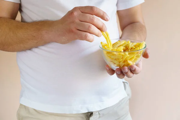 Hombre con sobrepeso comiendo patatas fritas de engorde — Foto de Stock