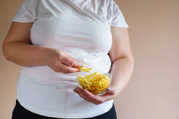 Mulher com sobrepeso comer batatas fritas de engorda — Fotografia de Stock