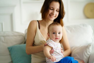 Oturma odasında erkek bebek ile oynarken annesi