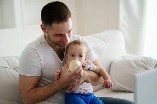 Baby boy drinken uit de fles. vader voeding zoon — Stockfoto