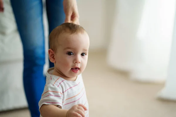 Babyjongen doen eerste stappen met moeders steun — Stockfoto