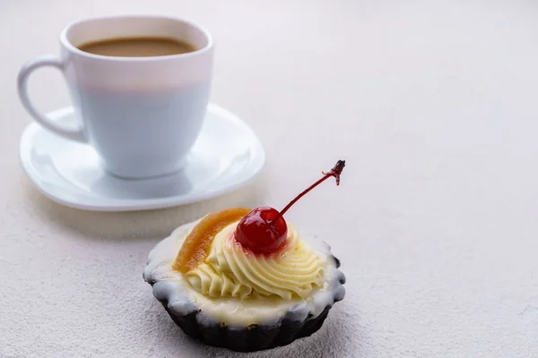 Cupcake coberto com uma cereja com chantilly — Fotografia de Stock