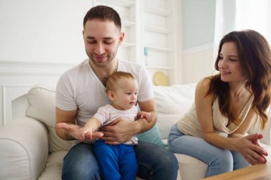 Anne, baba ve oğul oturma odasında eğleniyor