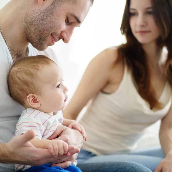 Madre e padre abbracciare il loro bambino figlio — Foto Stock