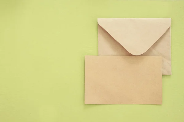 Mock-up letter or postcard with envelope on green background