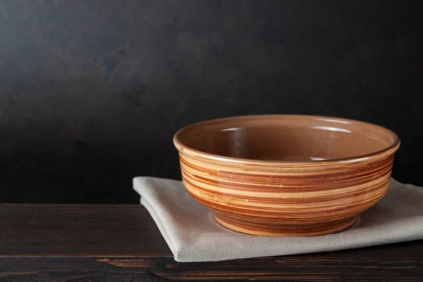 Empty bowl plate on wooden table over dark brown background -can be used for display or montage your products