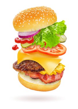Burger peynir, sosis, turşu, domates, soğan ve beyaz arka plan üzerinde izole marul ile uçan maddeler
