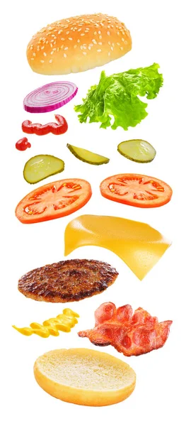Burger peynir, sosis, turşu, domates, soğan ve beyaz arka plan üzerinde izole marul ile uçan maddeler