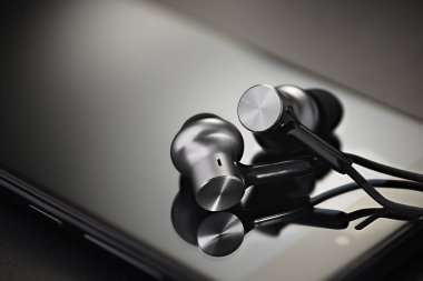 Alüminyum metal kulaklıkları siyah Smartphone cep telefonu ile. Taşınabilir müzik konsepti. Makro çekim