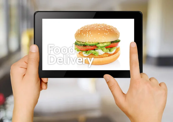 手与片剂订购汉堡包在线 食品输送理念 — 图库照片