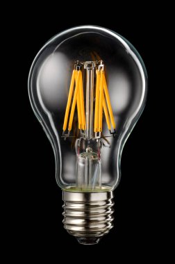 Modern transparent LED filament bulb isolated on black background clipart