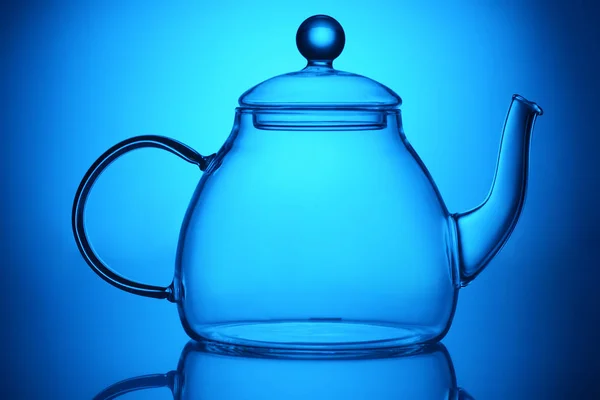 青の背景に透明な空のグラス ティーポット — ストック写真