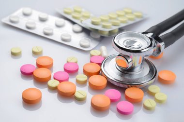 Sağlık stetoskop ve beyaz masa farklı renkli hapları yığını