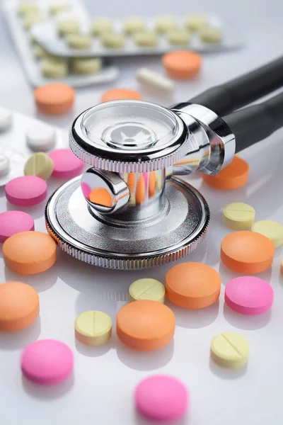 Medizinisches Stethoskop Und Haufen Verschiedenfarbiger Pillen Auf Weißem Tisch — Stockfoto