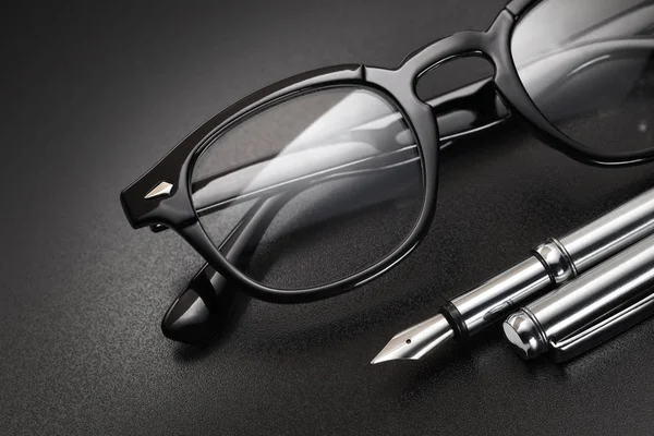 Lunettes en plastique noir et stylo plume — Photo