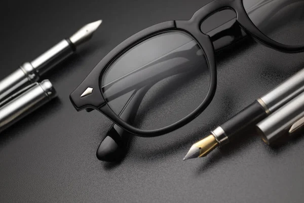 Lunettes en plastique noir et stylo plume — Photo