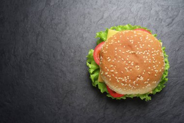 Classic cheeseburger on black slate background